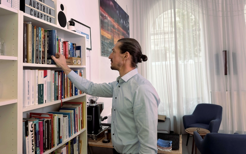 Foto von Philip Weihs am Bücherregal